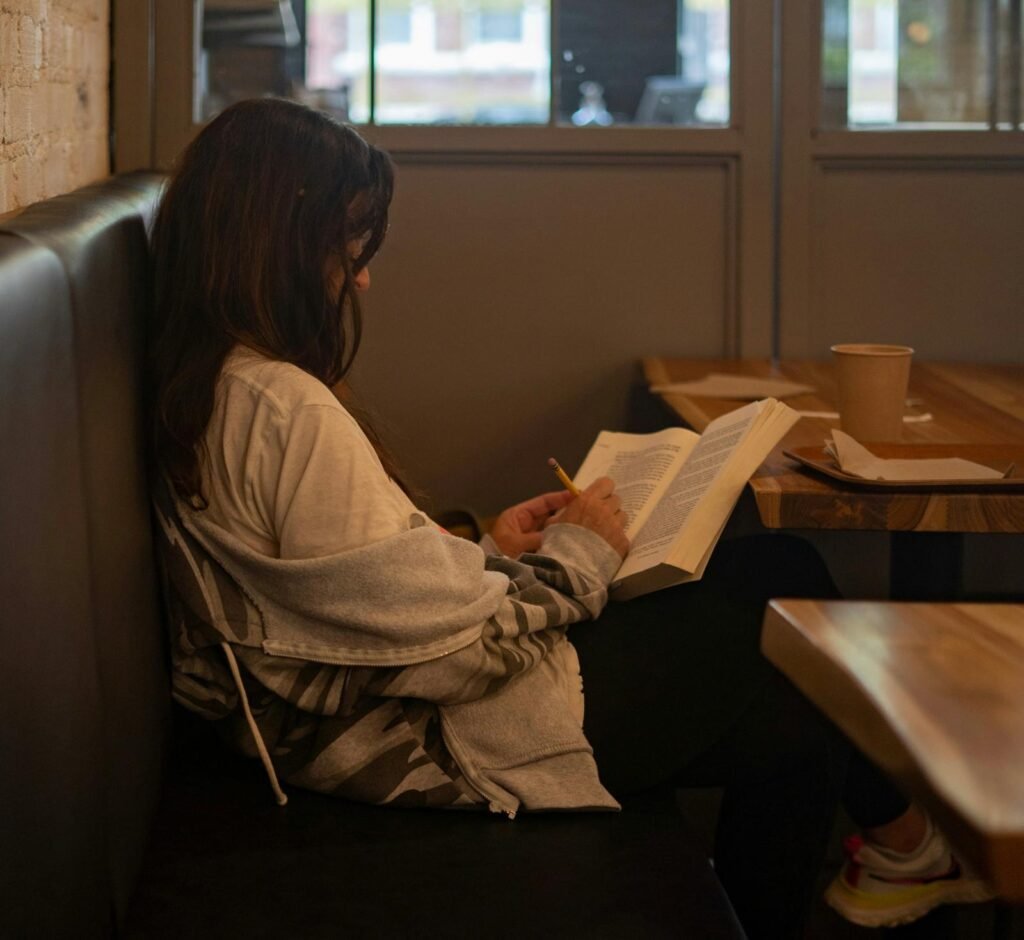 Woman reading a book alone in a cafe